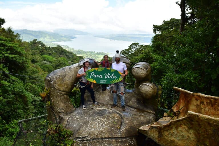 a group of people standing on a stone giant hand