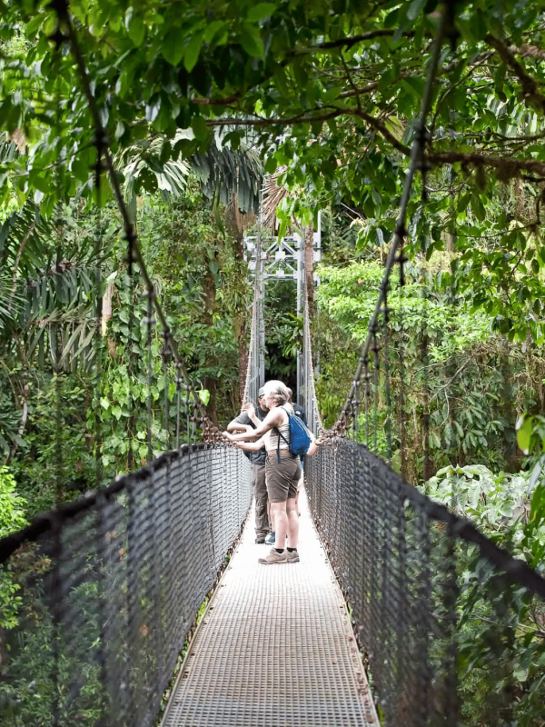 A couple walking in a hanging bridge in Arenal