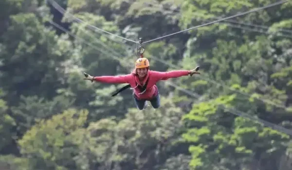 A lady doing a Superman Zip Line at the 100 Aventura Park