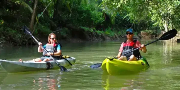 a man riding on the back of a boat in the water