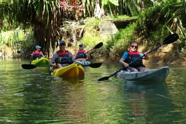 a group of people riding on the back of a boat in the water